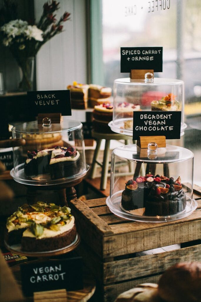 A tempting assortment of vegan cakes in a cozy bakery setting. Perfect for dessert lovers.
