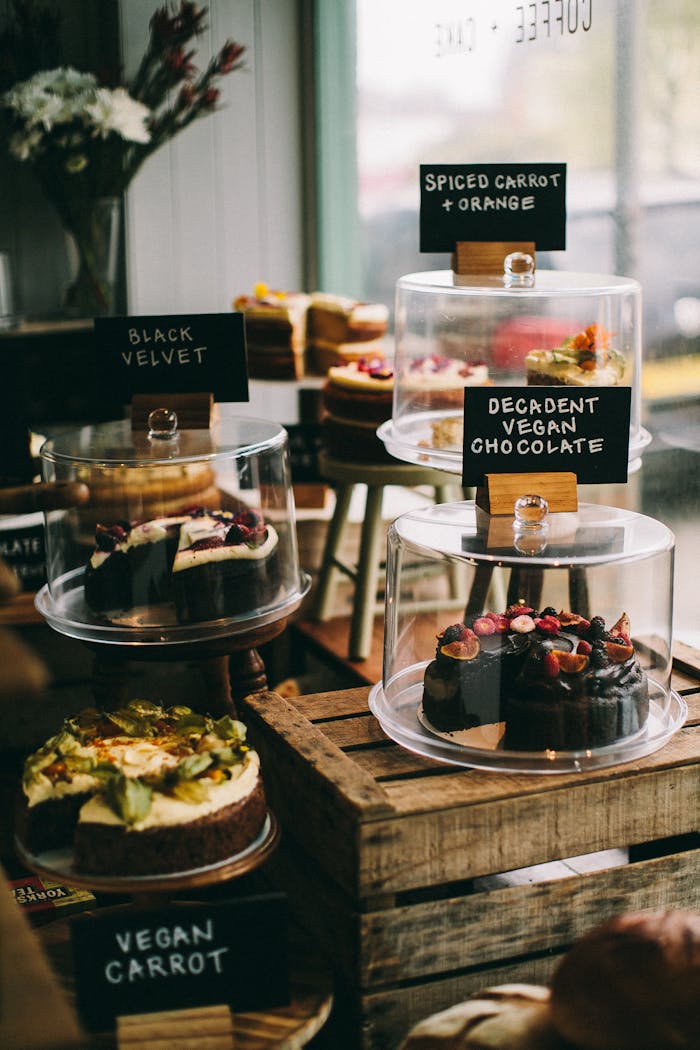 A tempting assortment of vegan cakes in a cozy bakery setting. Perfect for dessert lovers.