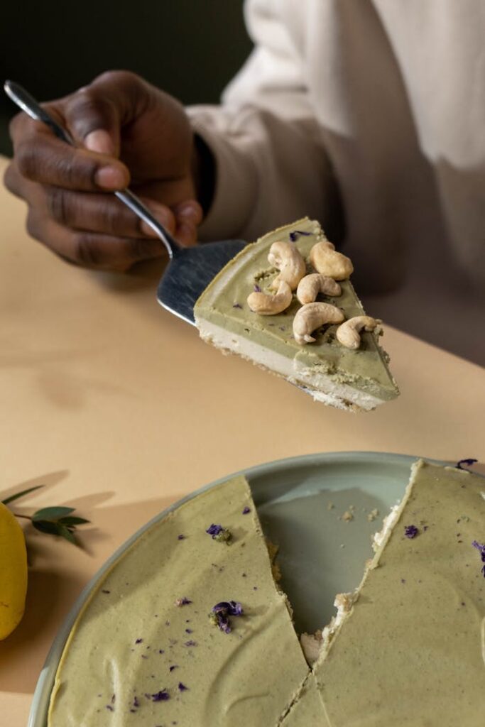 A slice of vegan cashew cake being served with a cake server on a tray.